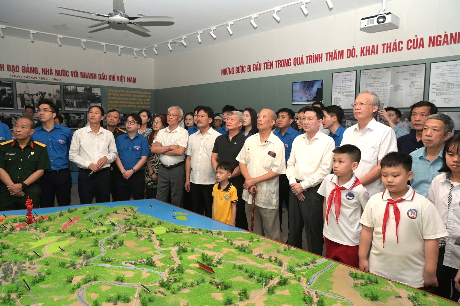 Các đại biểu, khách mời và các em thiếu nhi lắng nghe những hình ảnh tư liệu về về chặng đường hình thành và phát triển của ngành.